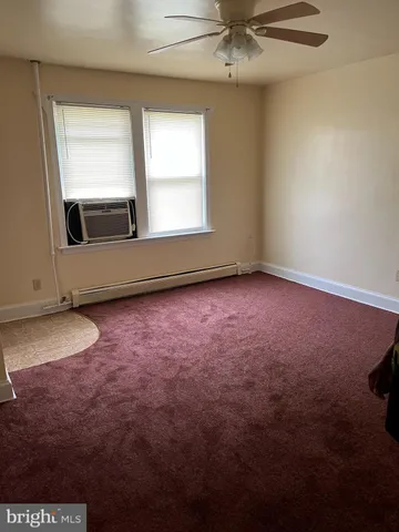 an empty room with a fan and a ceiling fan