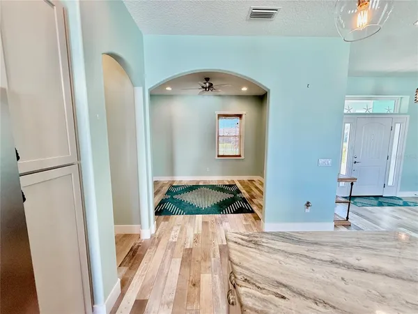 a view of a kitchen with refrigerator and wooden floor