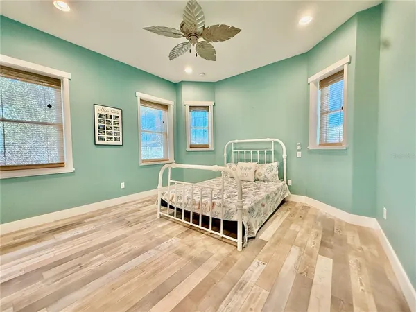 a view of a hallway with wooden floor and a bathroom