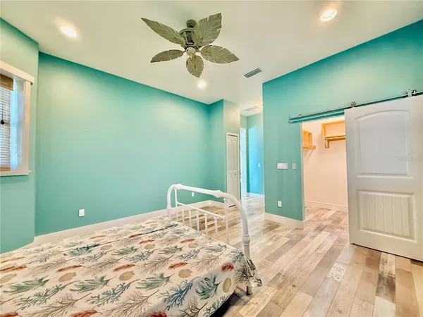 a view of a room with wooden floor and a ceiling fan