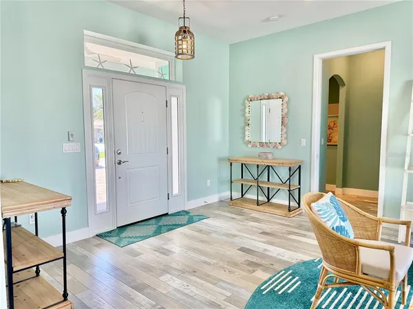 a kitchen with kitchen island granite countertop a dining table chairs refrigerator and cabinets