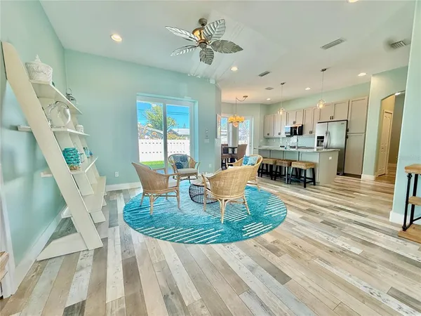 a living room with furniture a wooden floor and a chandelier