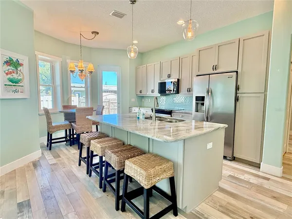 a kitchen with kitchen island a large counter top space appliances and cabinets