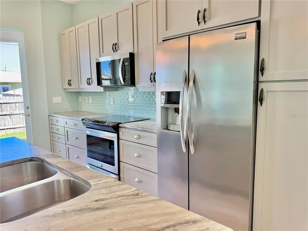 a kitchen with kitchen island granite countertop a sink and a stove
