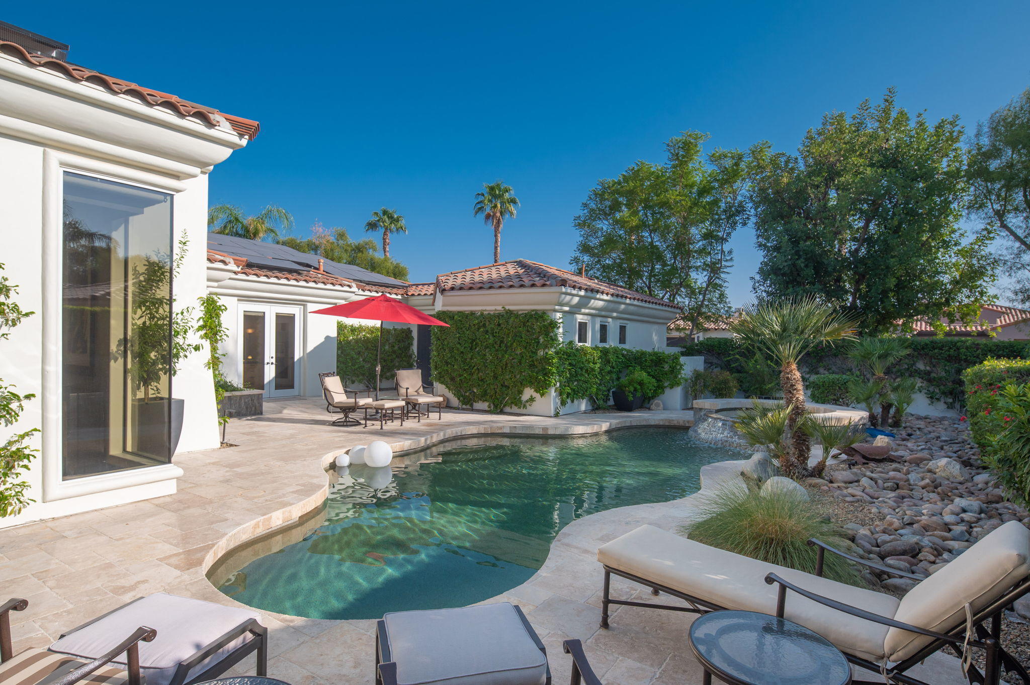 202 Loch Lomond Road Rancho Mirage, CA 92270 - Photo 32 of 47 a patio with a table and chairs under an umbrella