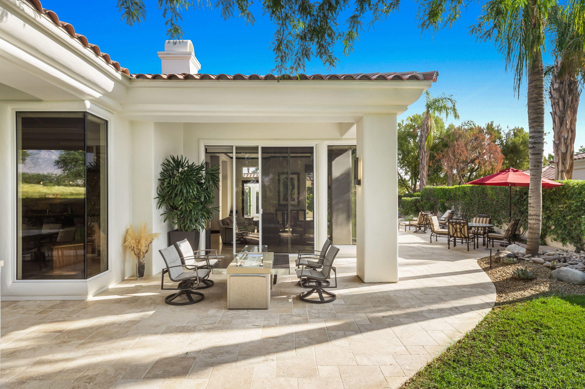202 Loch Lomond Road Rancho Mirage, CA 92270 - Photo 39 of 47 a view of a patio with a table and chairs under an umbrella
