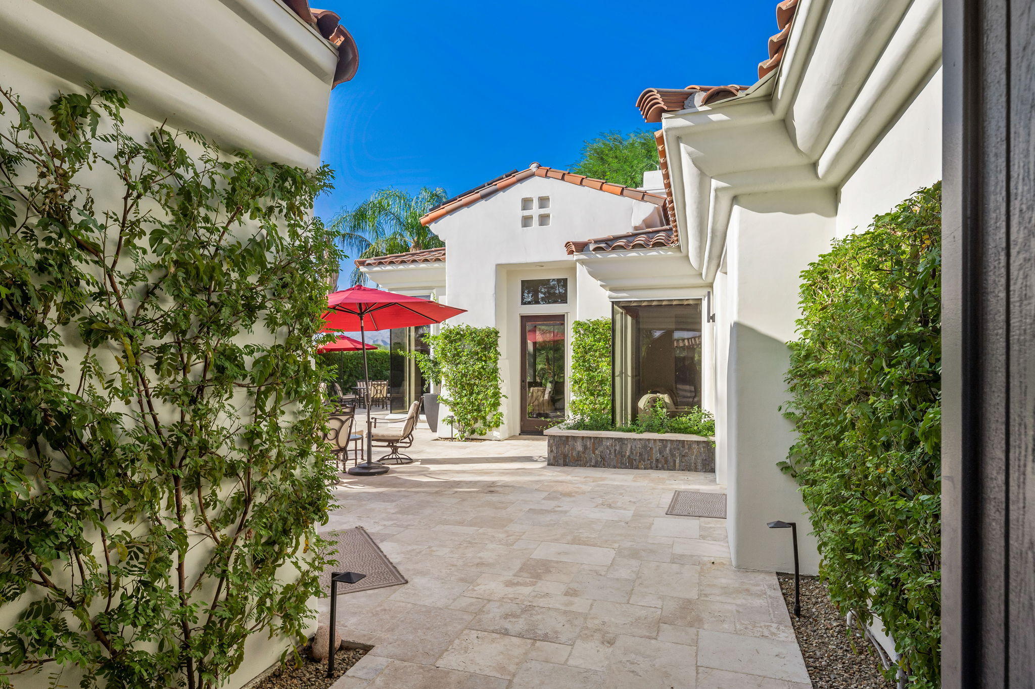 202 Loch Lomond Road Rancho Mirage, CA 92270 - Photo 6 of 47 a view of a white house with a yard and potted plants