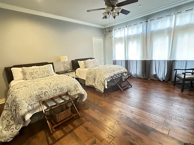 a spacious bedroom with two beds and a flat screen tv