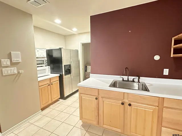a kitchen with a refrigerator and a sink