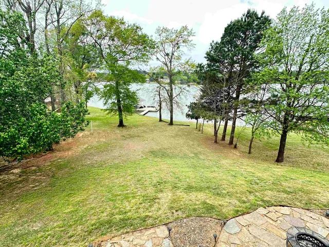 a brick building with a big yard and large trees
