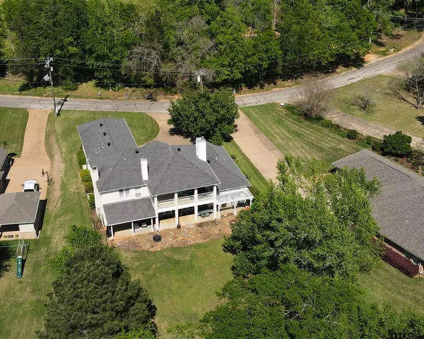 an aerial view of a house with a garden and lake view