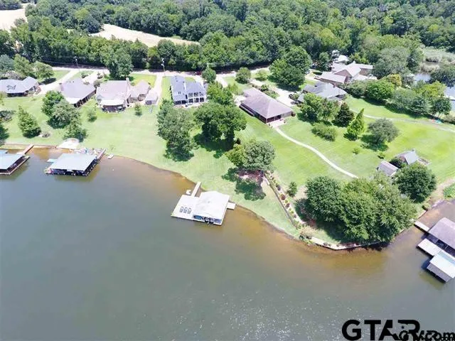 an aerial view of a house with garden space and lake view