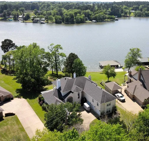 an aerial view of a house with garden space and lake view