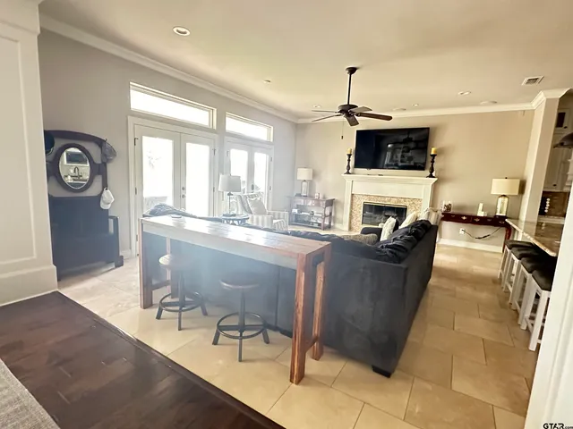 a living room with furniture a fireplace and a dining table with wooden floor