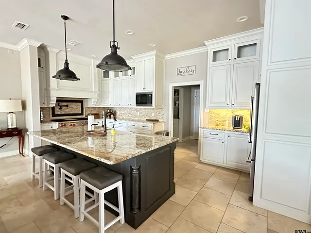 a kitchen with stainless steel appliances granite countertop a sink a stove and a refrigerator