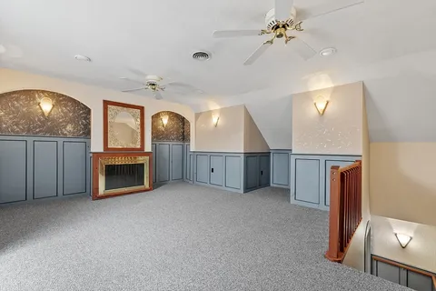 an empty room with windows fireplace and a kitchen view