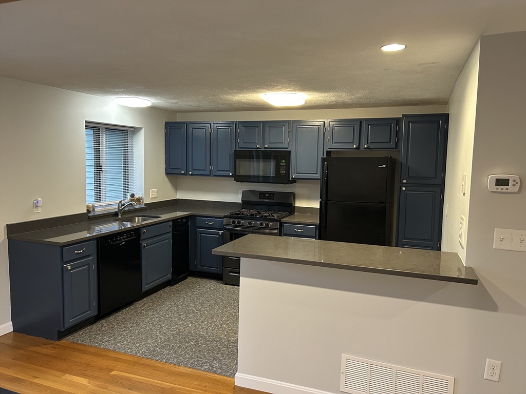 8 Deer Path, Unit 5 Maynard, MA 01754 - Photo 5 of 25 a kitchen with stainless steel appliances granite countertop a refrigerator and a stove
