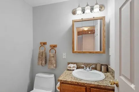 a bathroom with a sink and a mirror with toilet