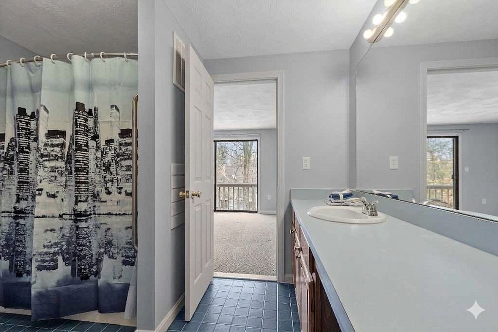 8 Deer Path, Unit 5 Maynard, MA 01754 - Photo 9 of 25 a en suite bathroom with a sink a mirror and shower
