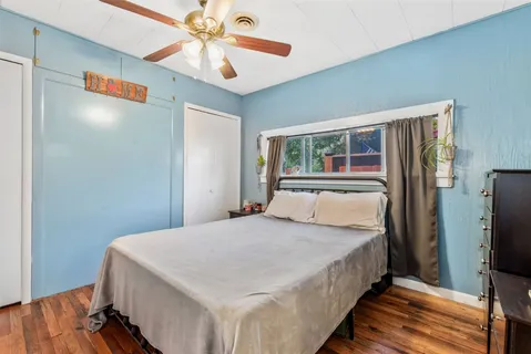 a bedroom with a large bed a flat tv screen and a walk in closet