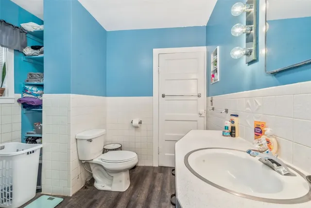 a bathroom with a sink a toilet and a large mirror