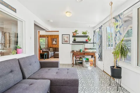a living room with furniture and a dining table with wooden floor