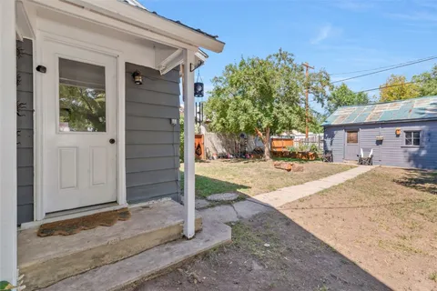 a view of a house with a tree in front of it