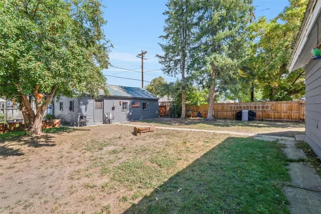 a view of a yard with a house and a large tree