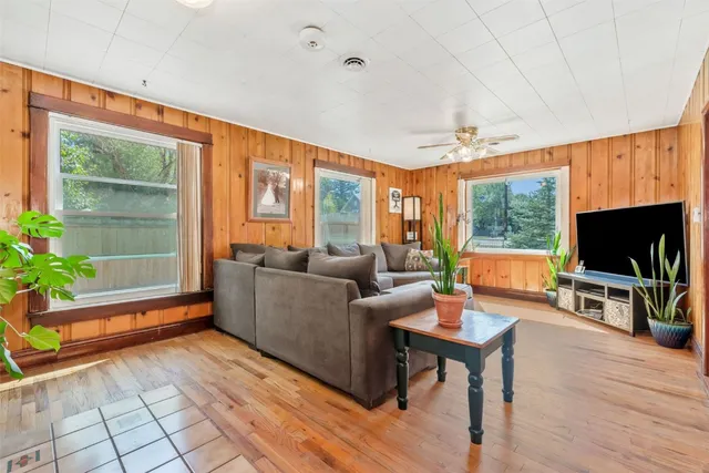 a living room with furniture a flat screen tv and wooden floor