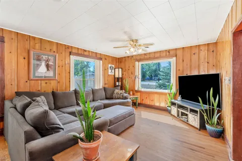 a living room with furniture a flat screen tv and a floor to ceiling window