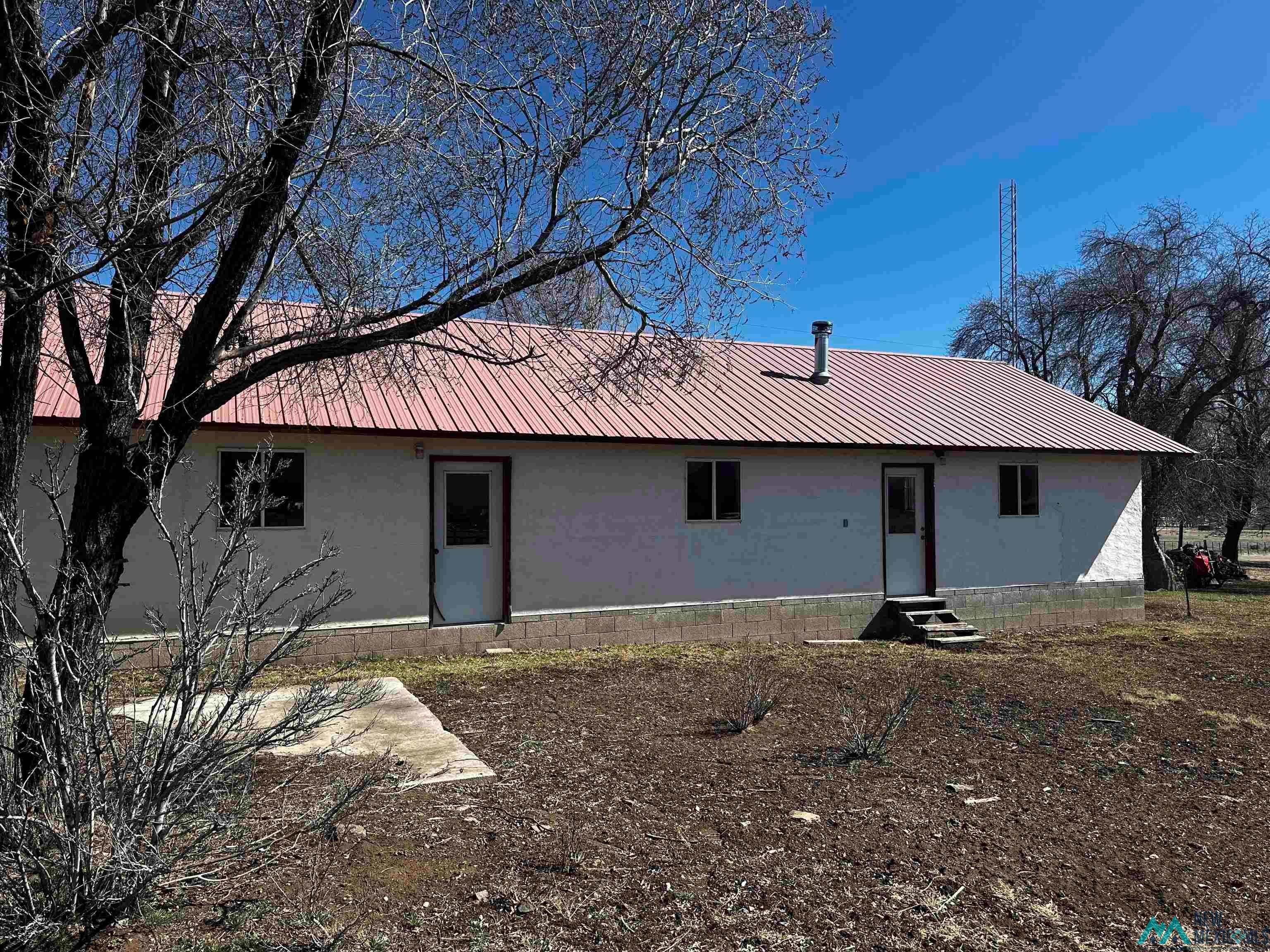 31 Bill Knight Gap Road Luna, NM 87824 - Photo 32 of 41 Rear view of property with stucco siding, a metal roof, and entry steps