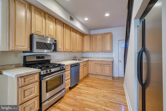 a kitchen with granite countertop cabinets stainless steel appliances and a window