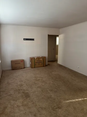 a view of an empty room with wooden floor and windows