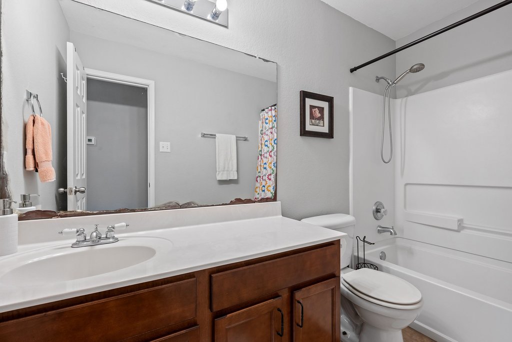 140 Wolfberry Path Buda, TX 78610 - Photo 30 of 35 a bathroom with a granite countertop toilet sink and a mirror