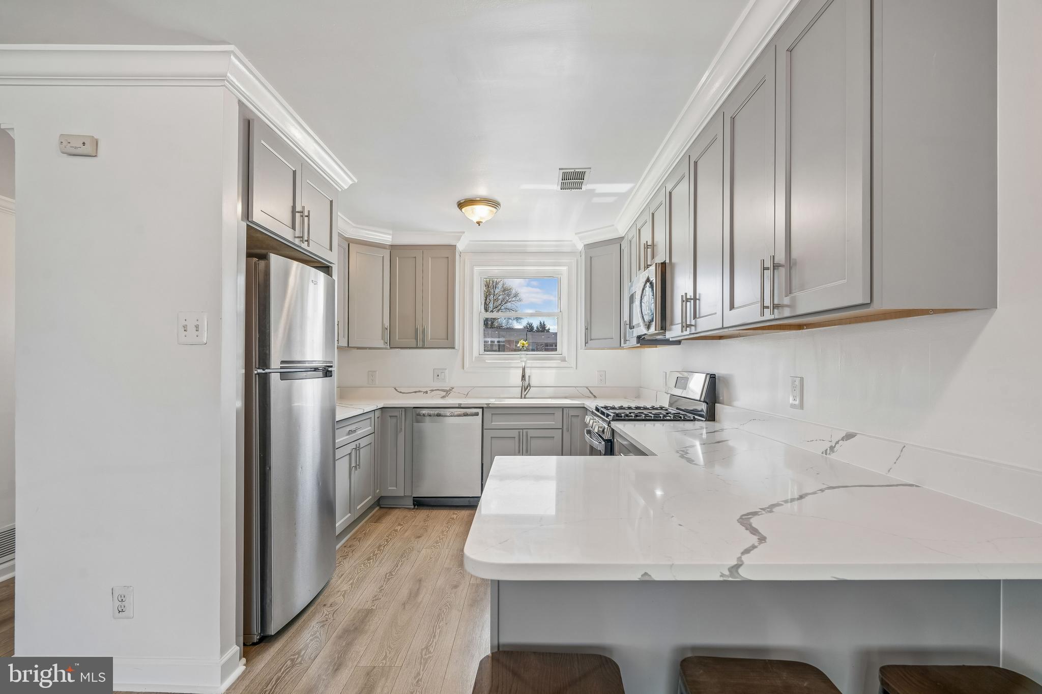 14418 Bel Pre Drive Silver Spring, MD 20906 - Photo 5 of 14 a kitchen with a sink refrigerator and cabinets