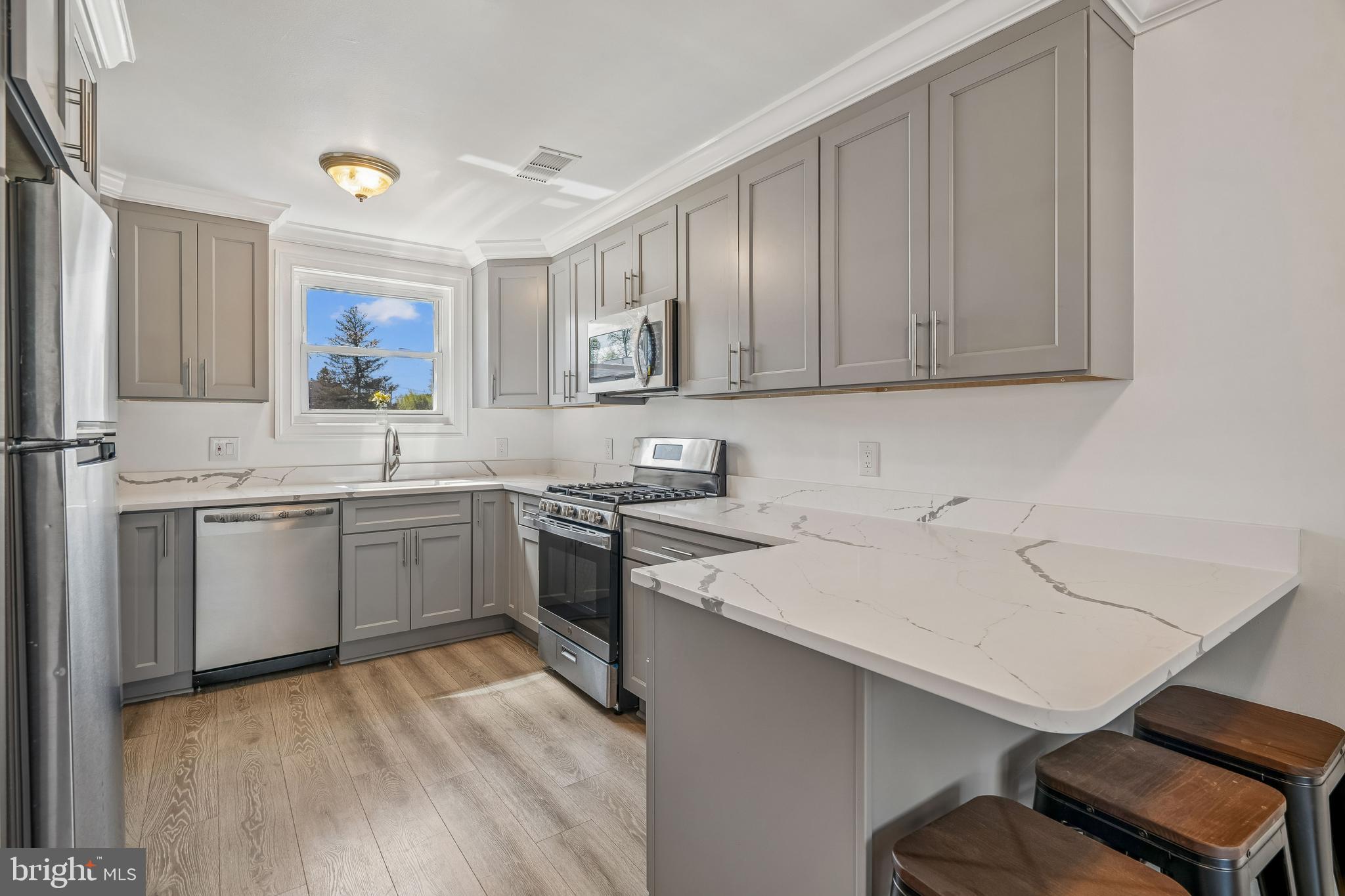 14418 Bel Pre Drive Silver Spring, MD 20906 - Photo 6 of 14 a kitchen with a sink cabinets and wooden floor