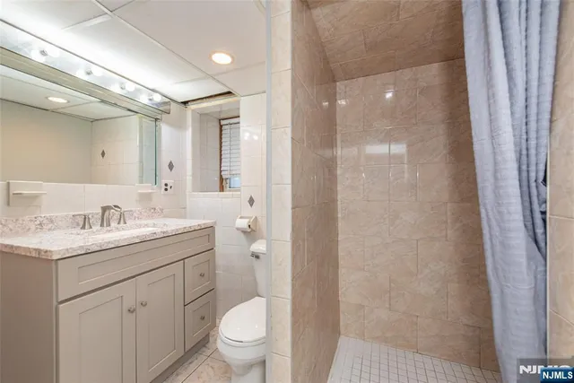 a bathroom with a granite countertop sink toilet a large mirror a shower and vanity