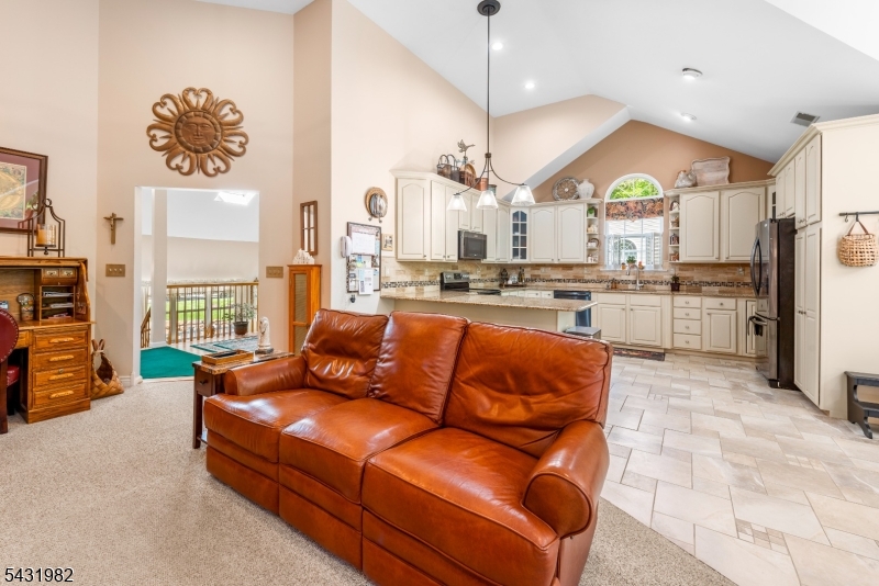 21 Towpath Lane Stanhope, NJ 07874 - Photo 12 of 37 a view of kitchen with stainless steel appliances granite countertop living room and couches with wooden floor