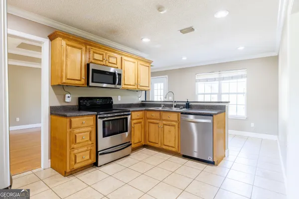 a kitchen with stainless steel appliances granite countertop a stove a sink and a microwave