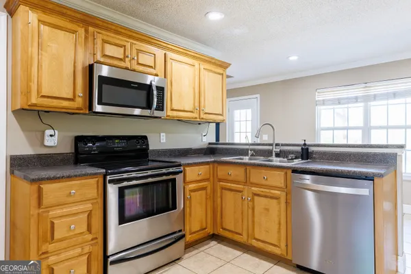 a kitchen with stainless steel appliances granite countertop a stove microwave and sink