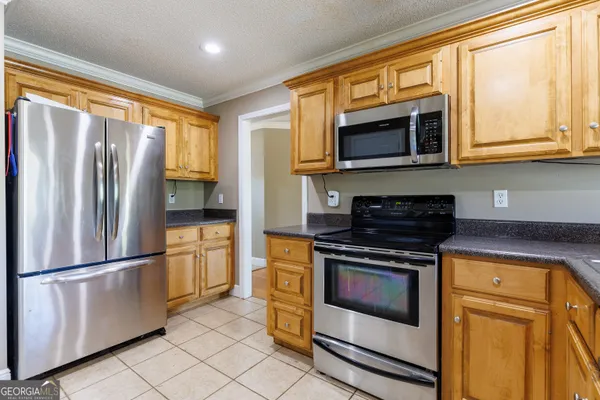 a kitchen with stainless steel appliances granite countertop a refrigerator stove and microwave