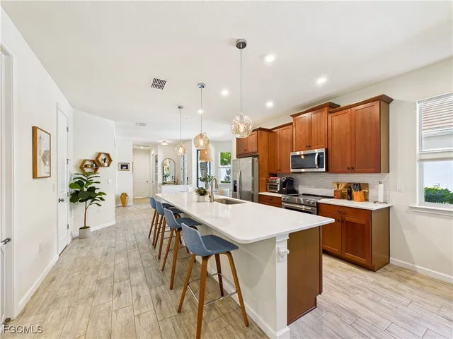 a large kitchen with kitchen island a sink table and chairs