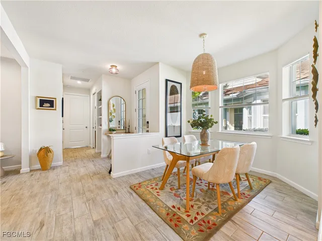 a dining room with wooden floor and a chandelier