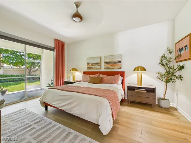 a bedroom with a bed and a large window with outer view