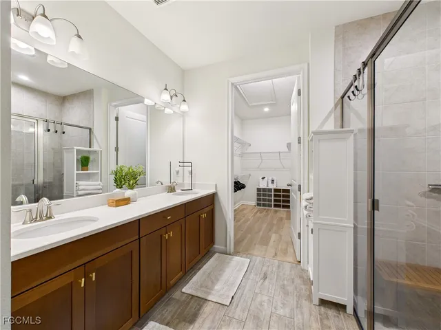 a bathroom with a double vanity sink a mirror and a shower