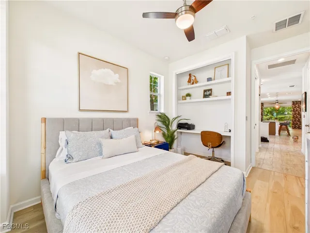 a bedroom with a bed mirror and painting on the wall