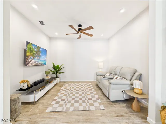 a living room with furniture rug and a ceiling fan