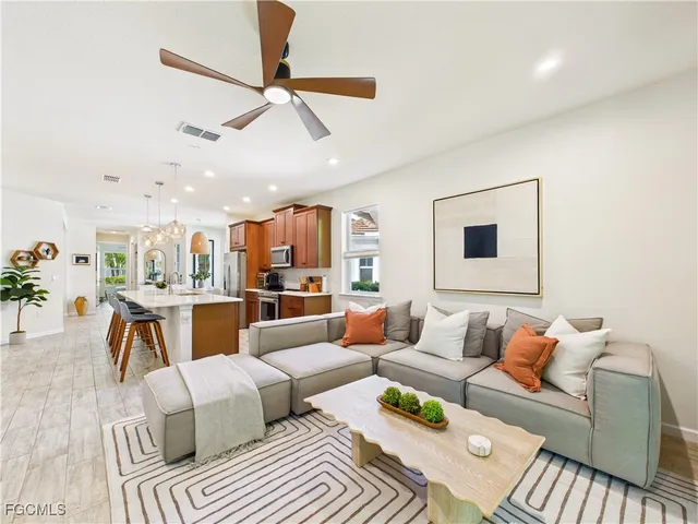 a living room with furniture kitchen view and a large window