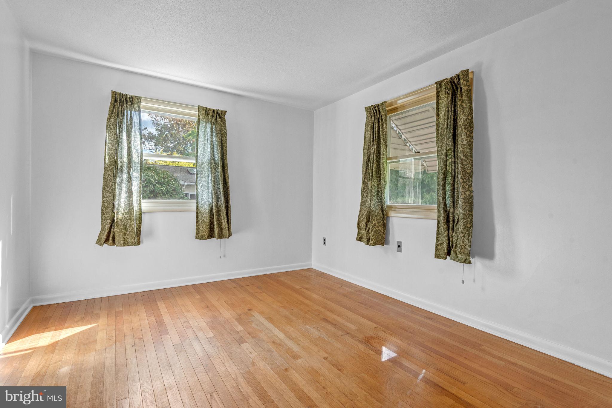 1818 Roxboro Road York, PA 17402 - Photo 9 of 39 a view of an empty room with wooden floor and a window