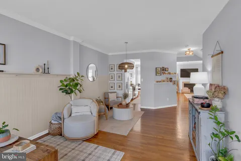 a living room with furniture a chandelier and a mirror